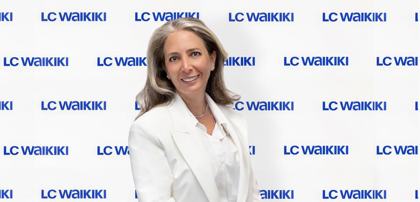 Banu Mengi'nin ayakta dururken beyaz ceketli gülümseyen fotoğrafı