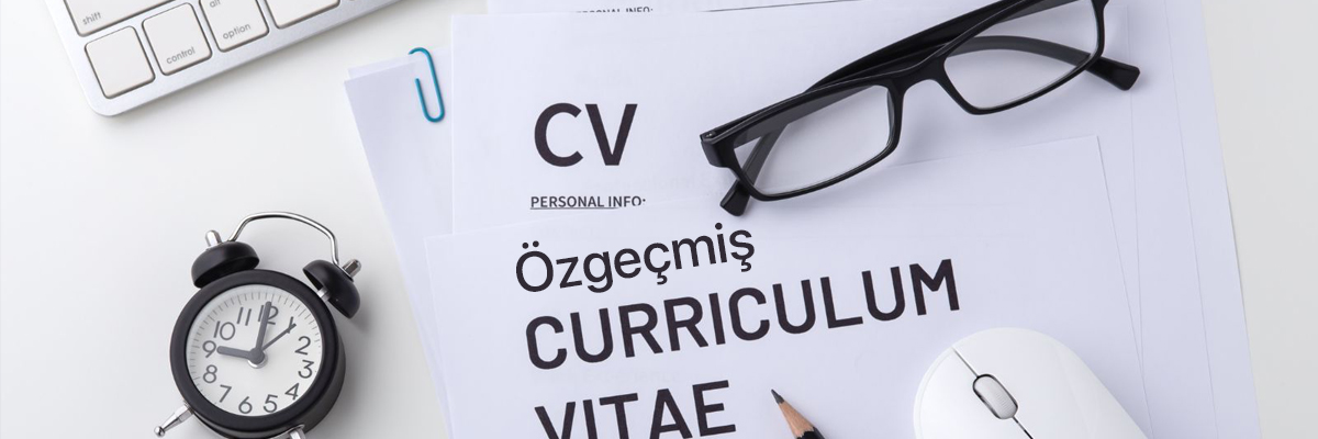Beyaz bir çalışma yüzeyinde özgeçmiş belgeleri, üzerine konmuş bir gözlük ve bir kurşun kalem duruyor. Sol tarafta küçük bir masa saati ve klavyenin bir kısmı, sağda ise beyaz bir bilgisayar faresi görülüyor. Düzenli bir masa üzerinde CV hazırlama temasını yansıtan sade bir görüntü.
